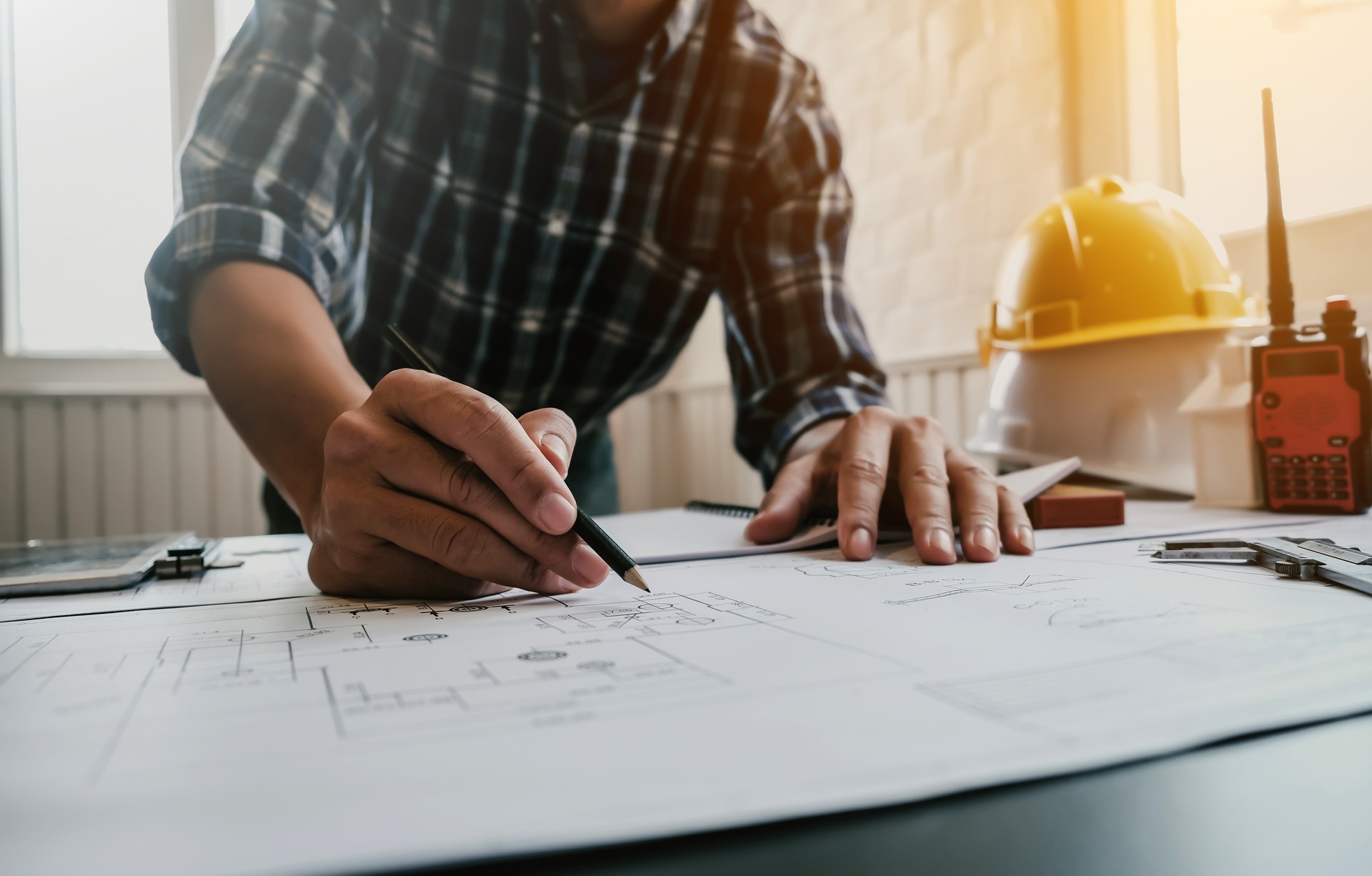 Male architect or engineer working at home drawing the construction project.